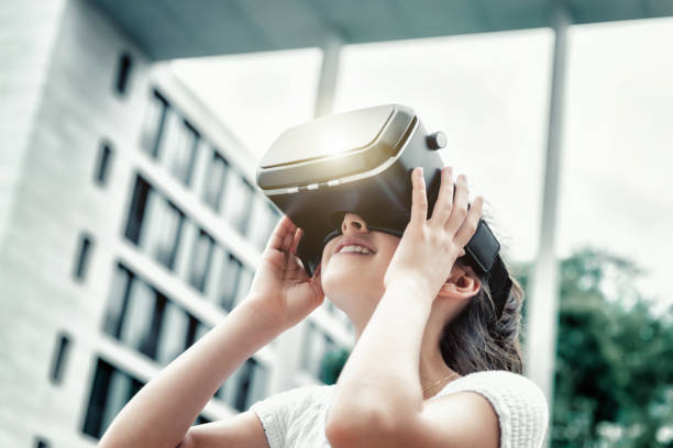 teenager-mädchen mit virtual-reality-simulator nachschlagen - head mounted display stock-fotos und bilder