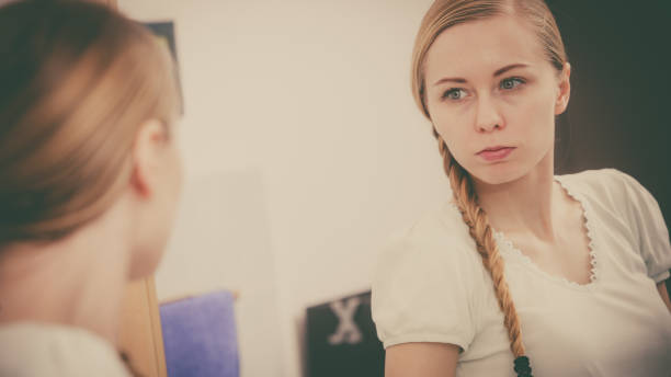 istock Woman looking at her reflection in mirror 822732370