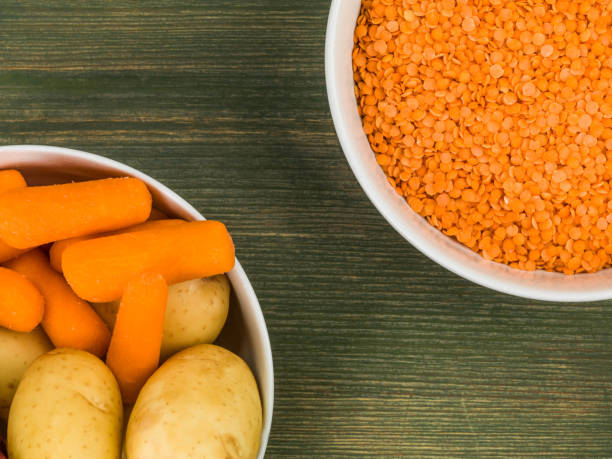 Bowl of Dry Uncooked Red Lentils Against a Green Wooden Background