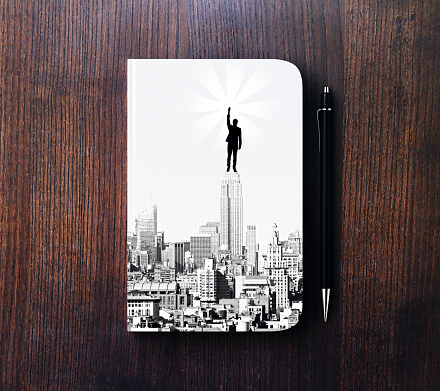 Top view of notepad with businessman on top of tower sketch, placed on wooden desktop with pen. Leadership concept. 3D Rendering