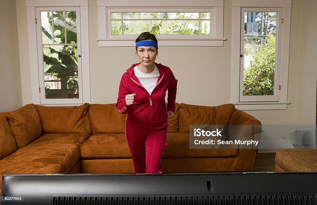 Woman exercising in front of television  Exercising Stock Photo