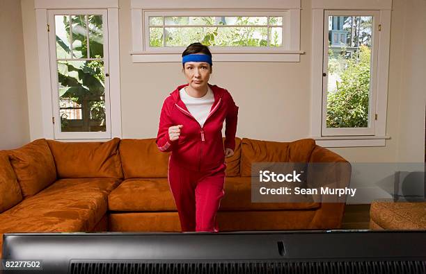 Woman Exercising In Front Of Television Stock Photo - Download Image Now - Exercising, Domestic Life, Sofa