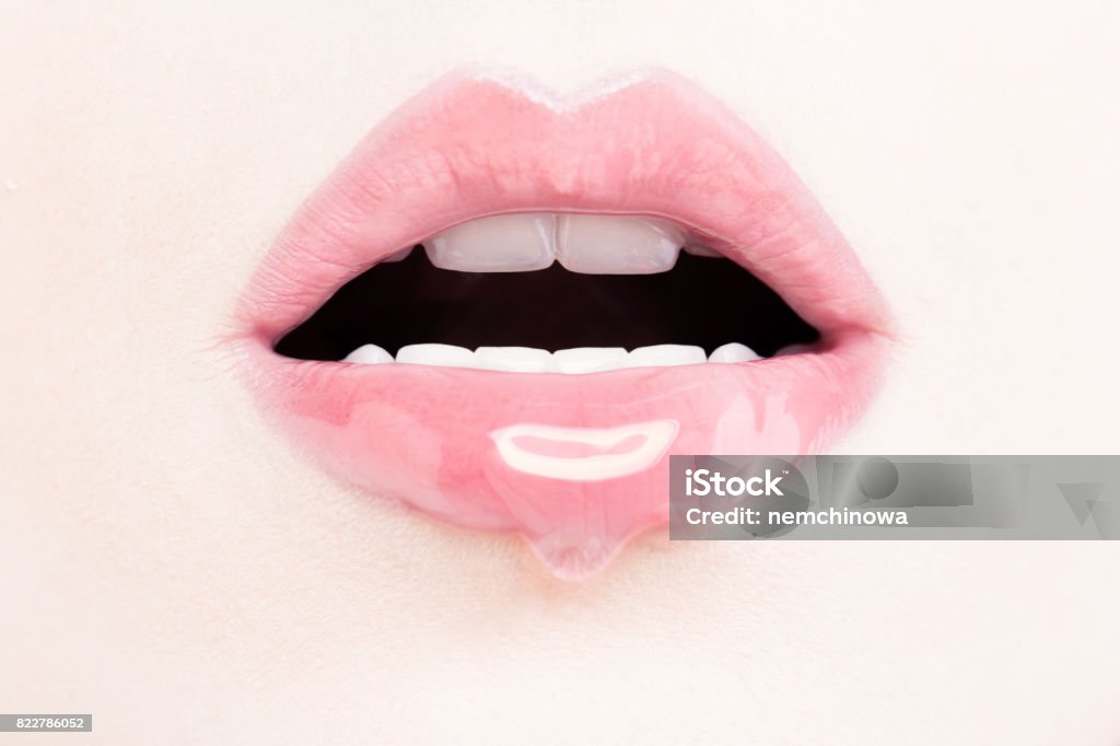 Female Lips with Pink Lip Gloss. Wet Lips with Makeup and Lip Gloss Drop Human Lips Stock Photo