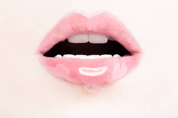 губы женщины с розовым блеском для губ. влажные губы с макияжем и блеском для губ - sexy lips стоковые фото и изображения