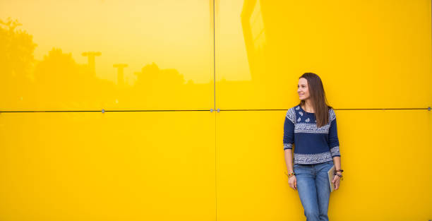 istock Woman standing by the yellow wall 822786832
