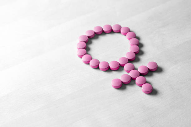 Medicine for woman. Menopause, pms, menstruation or estrogen concept. Female health. Gender symbol made from pink red pills or tablets on wooden table. Female sign made from medicine pills estrogen photos stock pictures, royalty-free photos & images