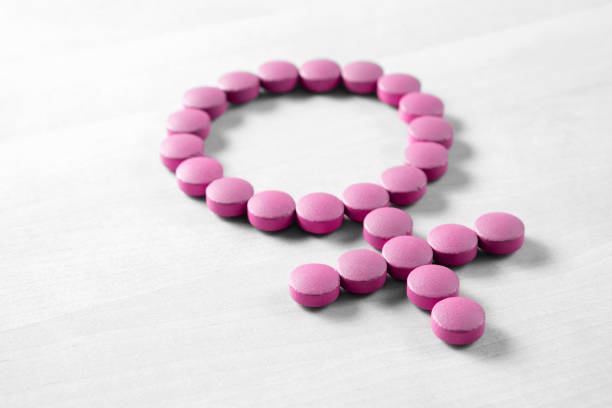 Medicine for woman. Menopause, pms, menstruation or estrogen concept. Female health. Gender symbol made from pink red pills or tablets on wooden table. Female health. Gender symbol made from pink red pills or tablets on wooden table estrogen photos stock pictures, royalty-free photos & images