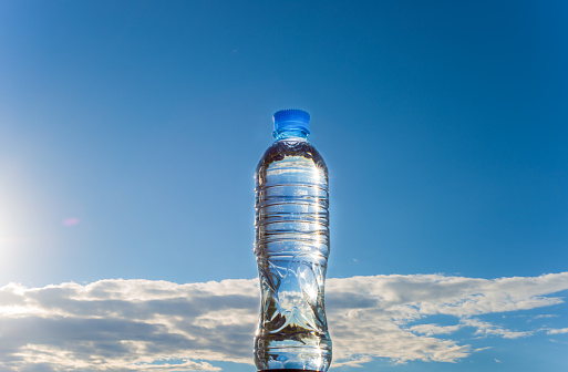 Plastic bottle with water on blue sky background