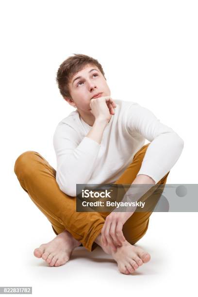 Pensive Teenager On White Stock Photo - Download Image Now - Sitting, Contemplation, Teenage Boys