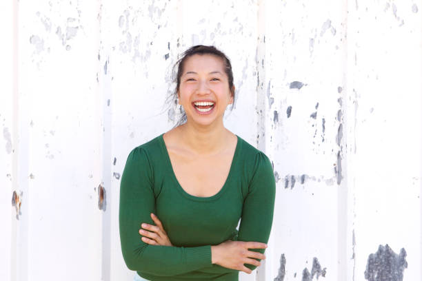 istock asian woman laughing against white wall 822863768