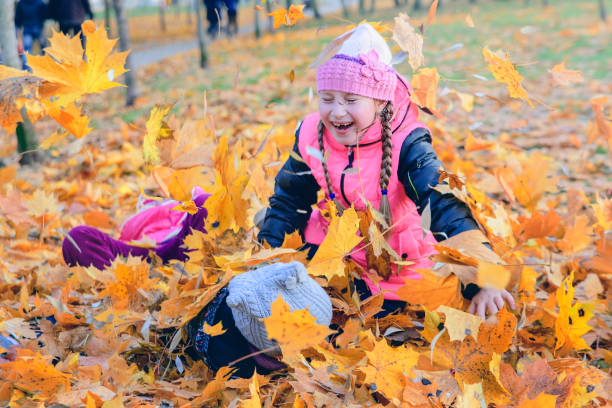 istock Children play in autumn Park.Falling leaves from trees. 822871464