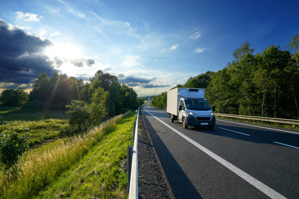 istock Delivery car on the road in a landscape at sunset 822878242