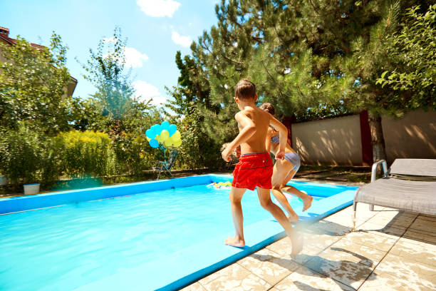 kinder springen in den pool im sommer - child jumping vegetable food stock-fotos und bilder