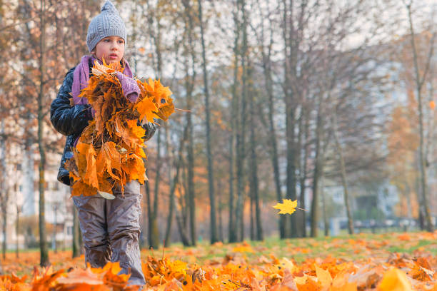 istock Children play in autumn Park.Falling leaves from trees. 822888762