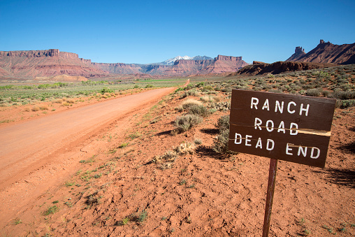 Warning sign by a remote dirt road in the southern Utah backcountry. American Southwest.