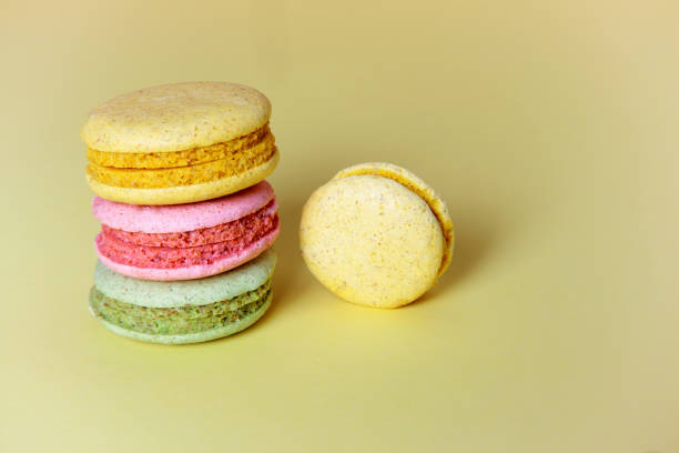 istock Stack of brightly colored macaroon  on a yellow background. Copy space for your design 822917284