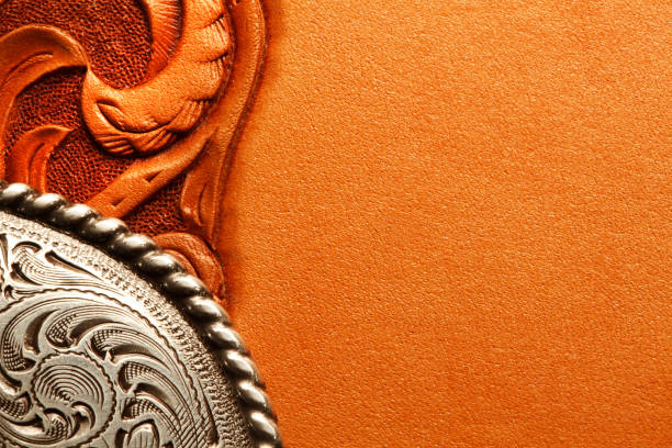 Western Style Belt Buckle On Tooled Leather Surface A silver belt buckle sits on top of a tooled leather surface. filligree stock pictures, royalty-free photos & images