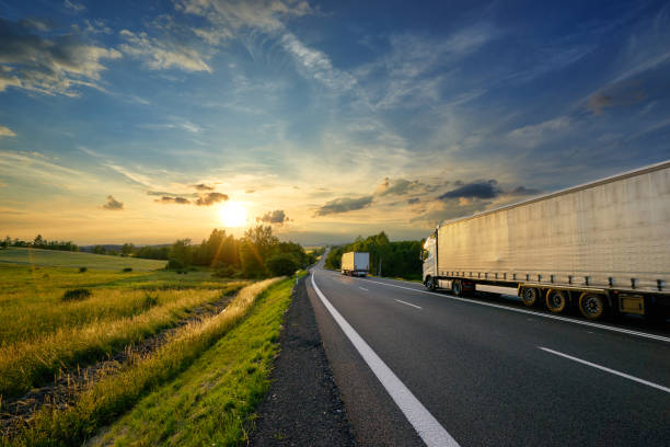 istock Trucks driving towards the setting sun on the road 822927464