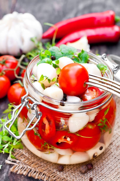 istock Marinated  cherry tomato with garlic and mixed chillies and herbs in glass jar 822952162
