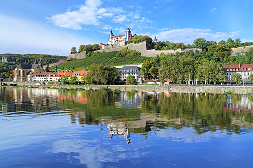 Wurzburg, Germany - September 29, 2013: Marienberg Fortress reflecting in the Main River. The fortress is a symbol of Wurzburg. Most of the current structures originally were built between 16th and 18th centuries.