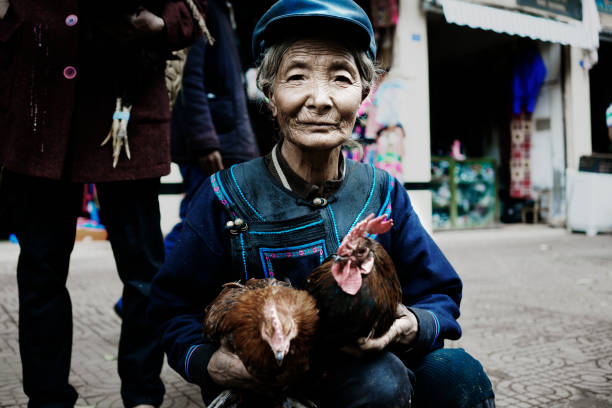 China Liangshan - August 19, 2016: An Yi woman sells chicken in the local market to get the necessities of life. Yi is one of the 56 ethnic minorities in China.