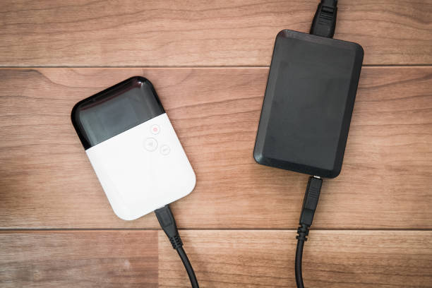 istock Pocket wifi with battery charger on brown wood table 823012948