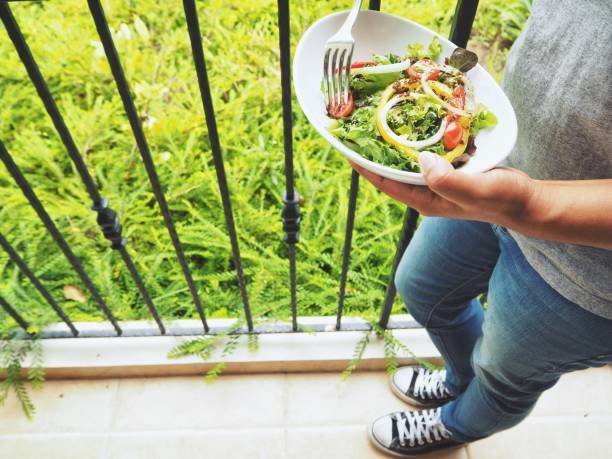 istock Woman eating fresh vegetable salad 823018132