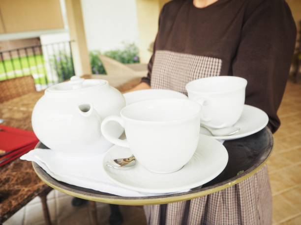 istock Woman serving with tea pot and cup 823018264
