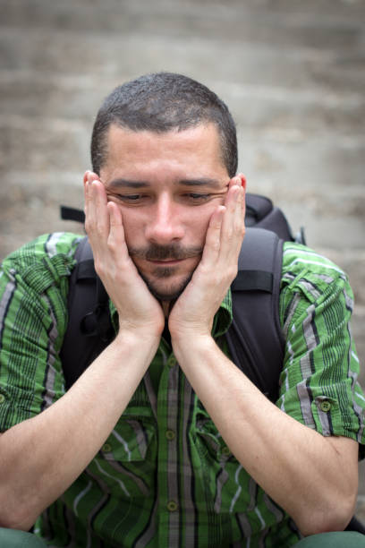istock Young man suffering depression sitting on ground street concrete stairs 823060972