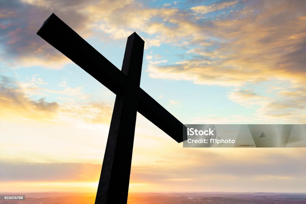 Cross silhouette and the clouds Cross in silhouette with a colorful sky and cloud Bible Stock Photo