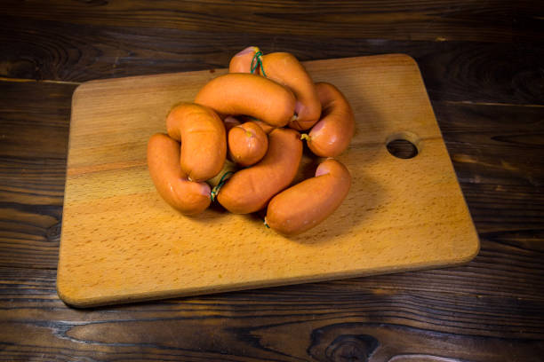 istock Sausages on cutting board on wooden table 823082314