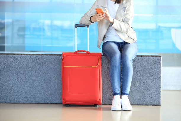 istock Red suitcase near sitting girl 823090544