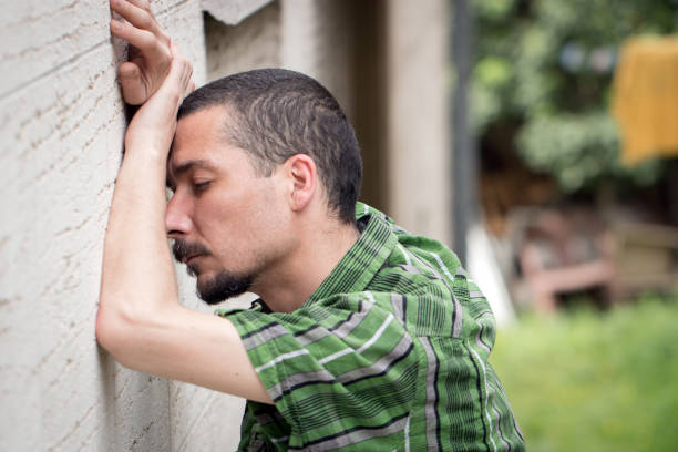istock Depressed and desperate man leaning against the wall 823094422
