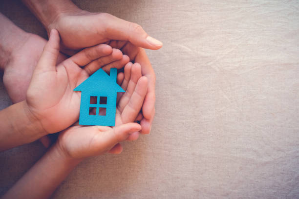 Adult and child hands holding paper house, family home and real estate concept Adult and child hands holding paper house, family home and real estate concept homelessness stock pictures, royalty-free photos & images