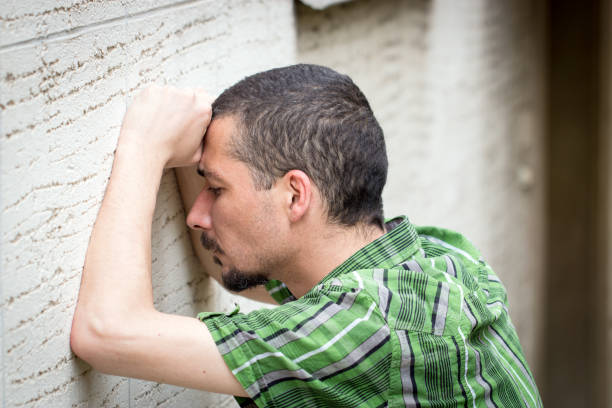 istock Depressed and desperate man leaning against the wall 823097120