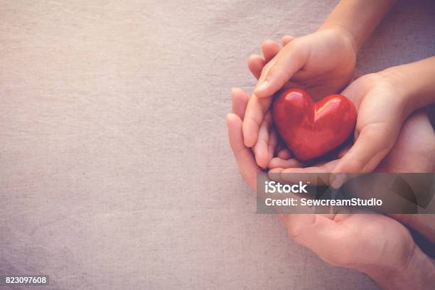 Foto de Coração De Holiding Vermelho De Mãos De Adulto E Criança Amor Saúde E Conceito De Família e mais fotos de stock de Caridade e assistência