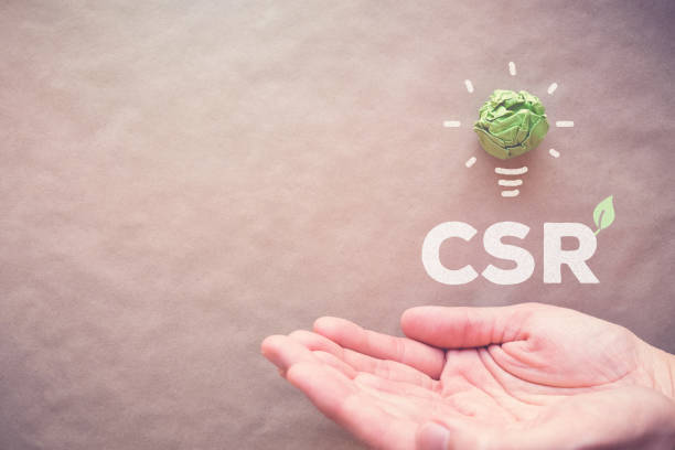 istock Green paper light bulb with CSR over hands, Corporate social responsibility 823103414