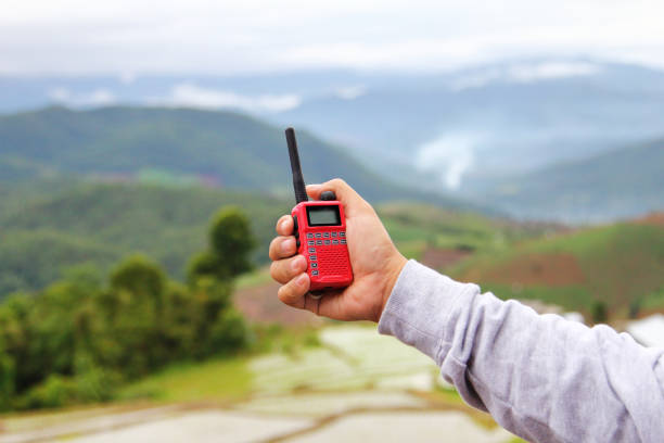 radio comunicación (walkie-talkie radio) en la mano, sobre fondo natural - uhf fotografías e imágenes de stock