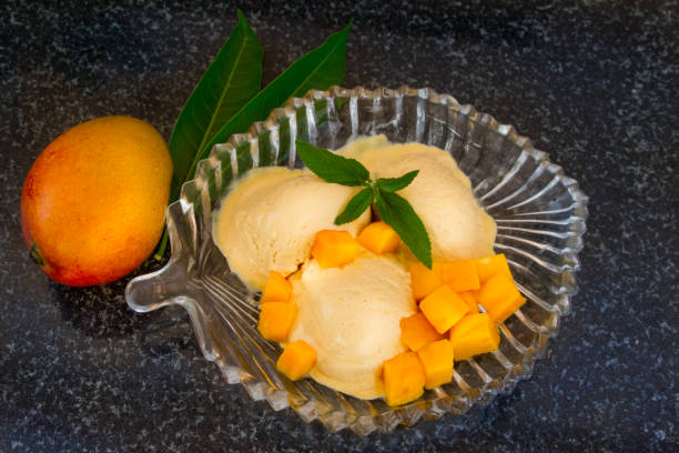 istock Mango ice cream with fresh mango slices with leaves mint on a glass plate. 823128042