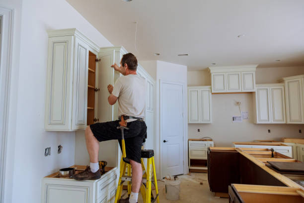 istock Installation of kitchen. Worker installs doors to kitchen cabinet. 823181154