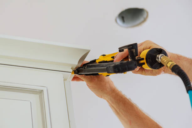 istock Carpenter brad using nail gun to Crown Moulding on kitchen cabinets framing trim, 823181508
