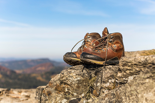 Winter sports style woman's Hiking boots on the rock. Natural leather and fur. Heavy-duty cold-resistant outsole