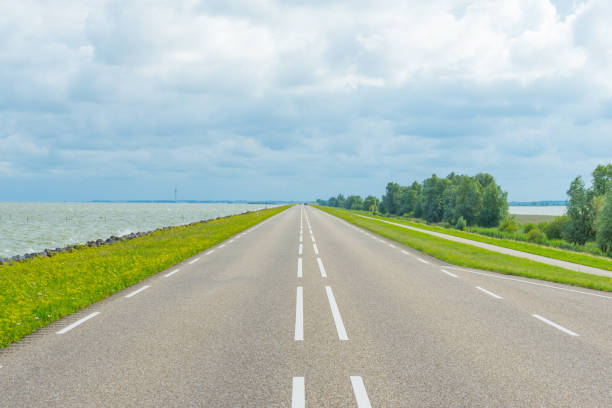 istock Road over a dike along a lake in summer 823255166