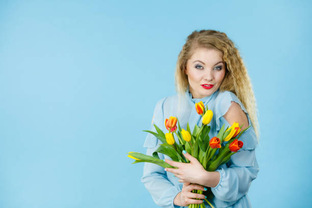 istock Pretty woman with red yellow tulips bunch 823255844