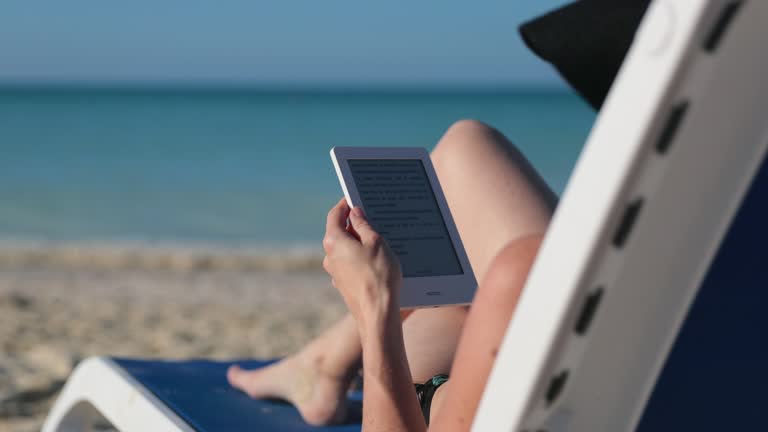 Woman Relaxing at Beach with Electronic Book Reader