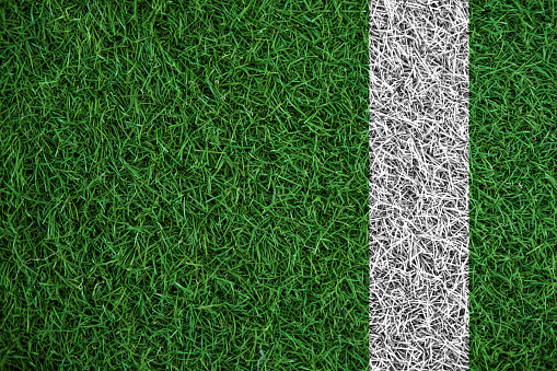 Green turf grass texture with white line, in soccer field