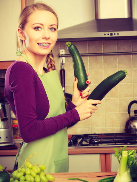 istock Woman in kitchen holds zucchini vegetable 823260230
