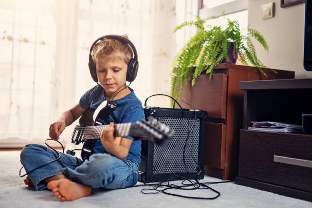 little toddler girl playing ukulele in music class.