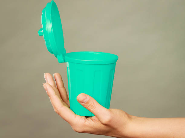 istock Woman putting paper into small trash can 823263630