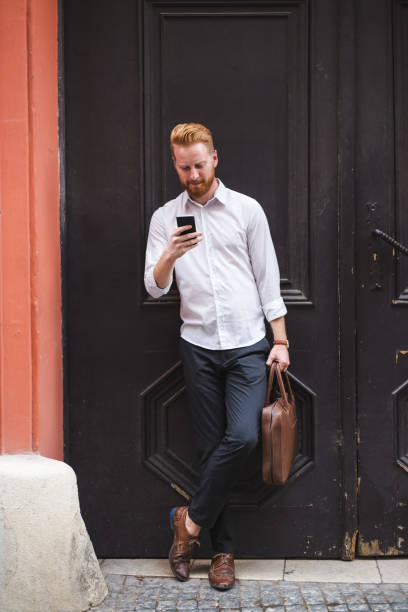 istock Modern young businessman in front of rustick door texting with clients 823268470
